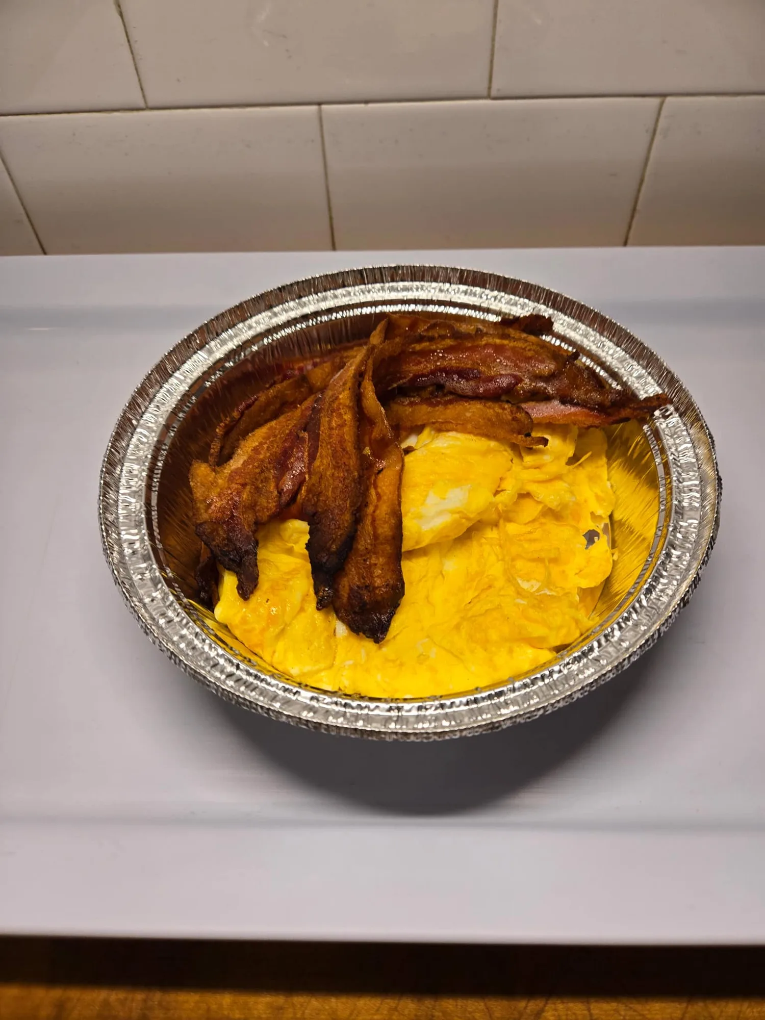 A breakfast platter of bacon and scrambled eggs